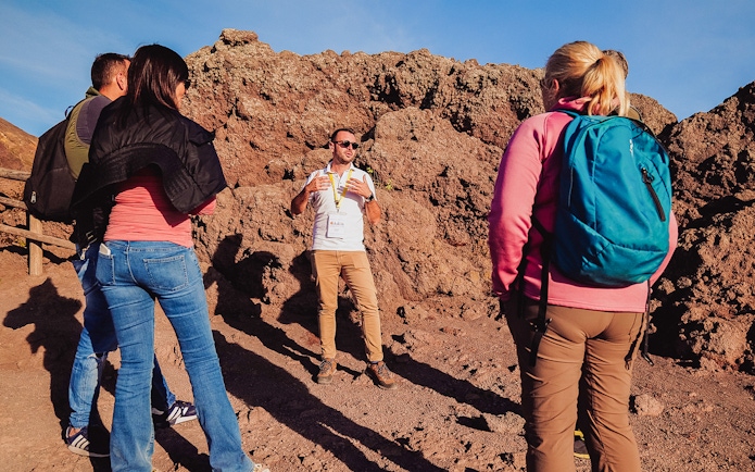 Tour guide explaining volcanic features to a group at Mt. Vesuvius, Italy.