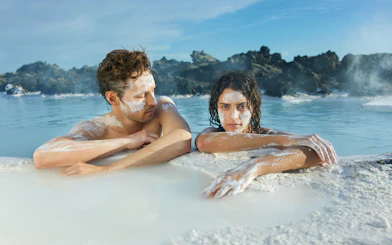 Couple relaxing in geothermal waters at Blue Lagoon, Iceland.
