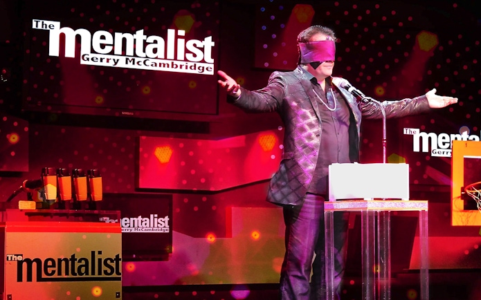 Performer on stage with blindfold during The Mentalist show.