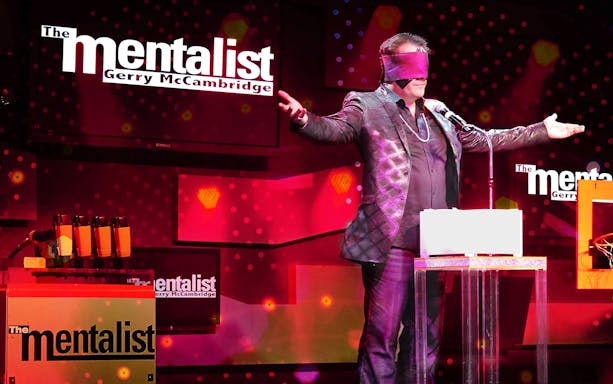 Performer on stage with blindfold during The Mentalist show.