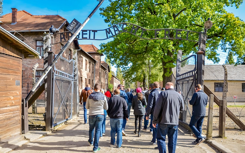 Visitors entering through the Arbeit macht frei gate at Auschwitz Birkenau, Krakow.