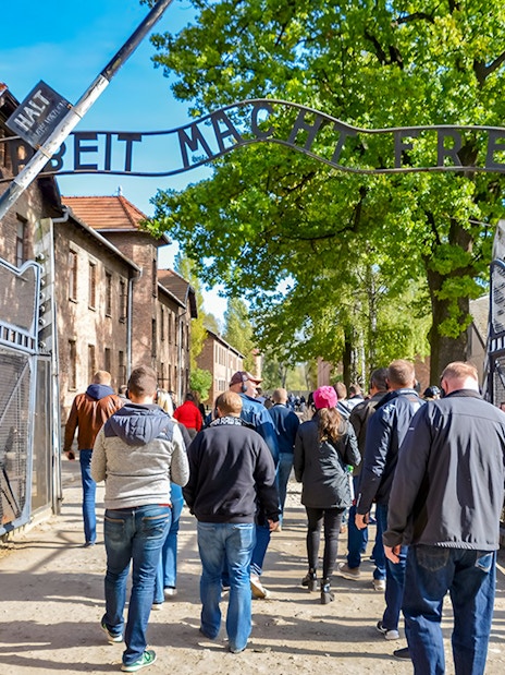 Visitors entering through the Arbeit macht frei gate at Auschwitz Birkenau, Krakow.