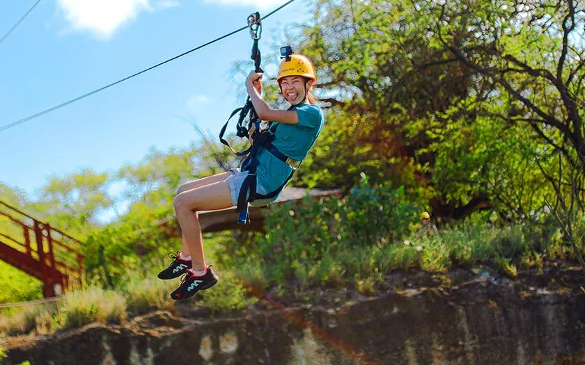 Ziplining through lush forest with modern braking system and expert guide.