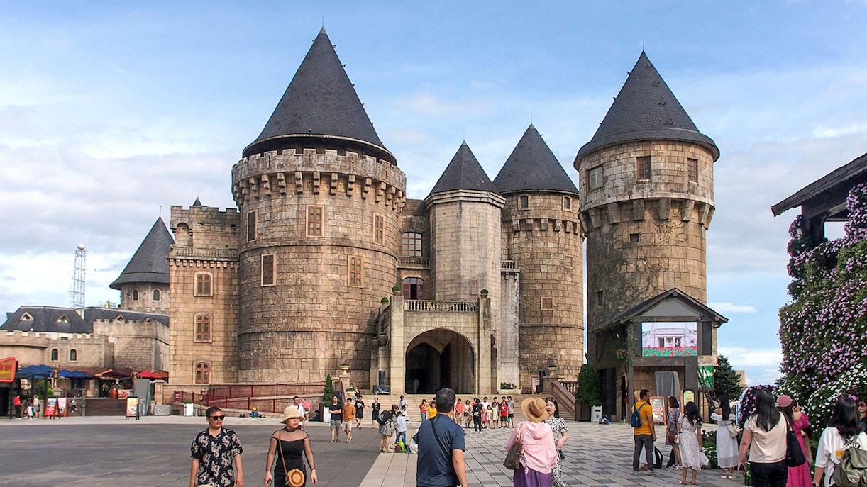 Ba Na Hills castles with cable cars in Da Nang, Vietnam, surrounded by lush greenery.