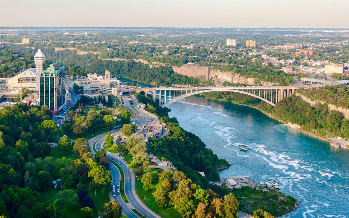 Rainbow Bridge spanning Niagara River on Niagara Parkway, with surrounding greenery and cityscape.