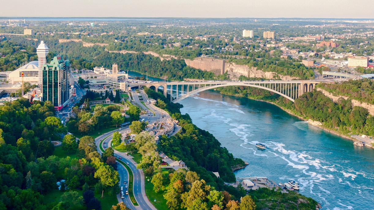 Rainbow Bridge spanning Niagara River on Niagara Parkway, with surrounding greenery and cityscape.