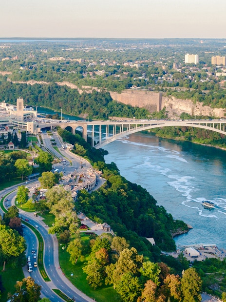 Rainbow Bridge spanning Niagara River on Niagara Parkway, with surrounding greenery and cityscape.