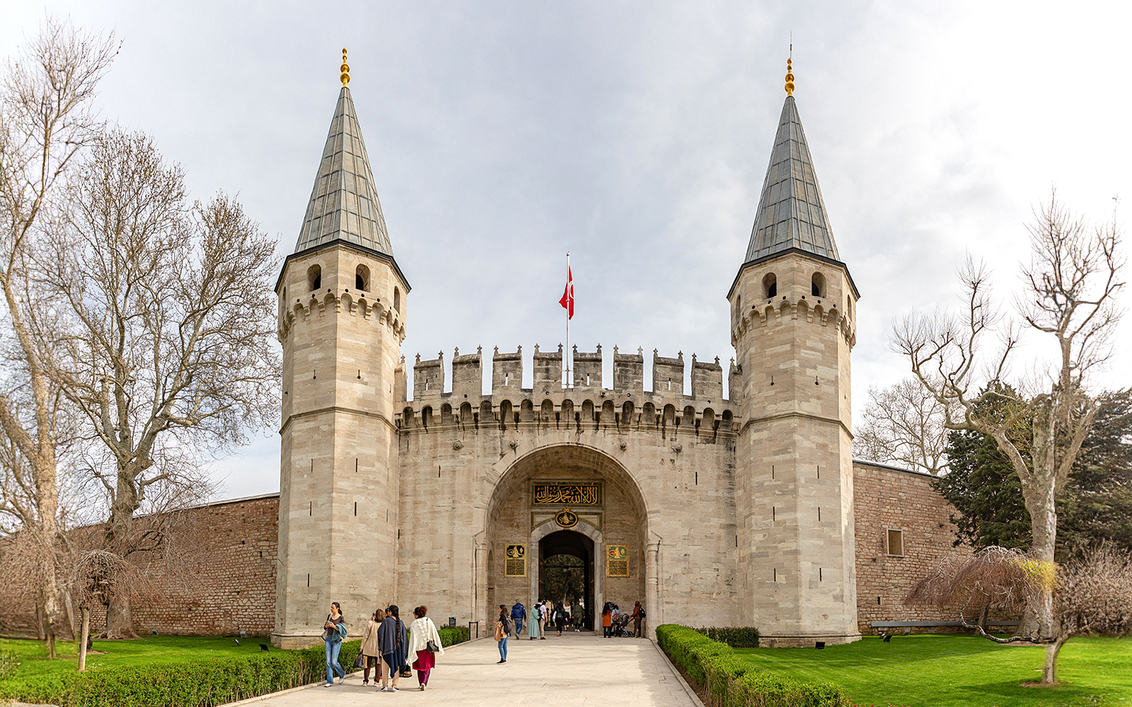 Topkapi Palace entrance with tourists exploring the historic site in Istanbul.