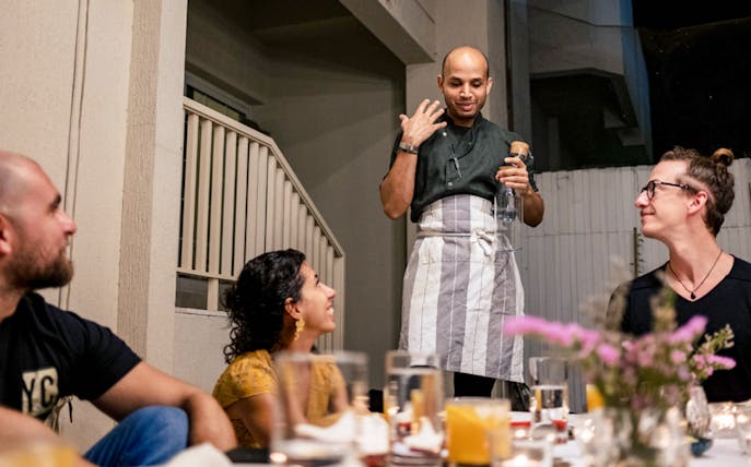 Chef presenting to guests at Chef Kuv's Secret Supper, an underground dining experience.