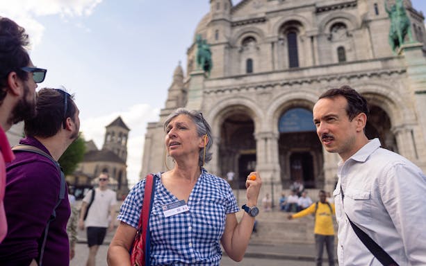 Guide leading a Montmartre walking tour near Sacré-Cœur Basilica in Paris.
