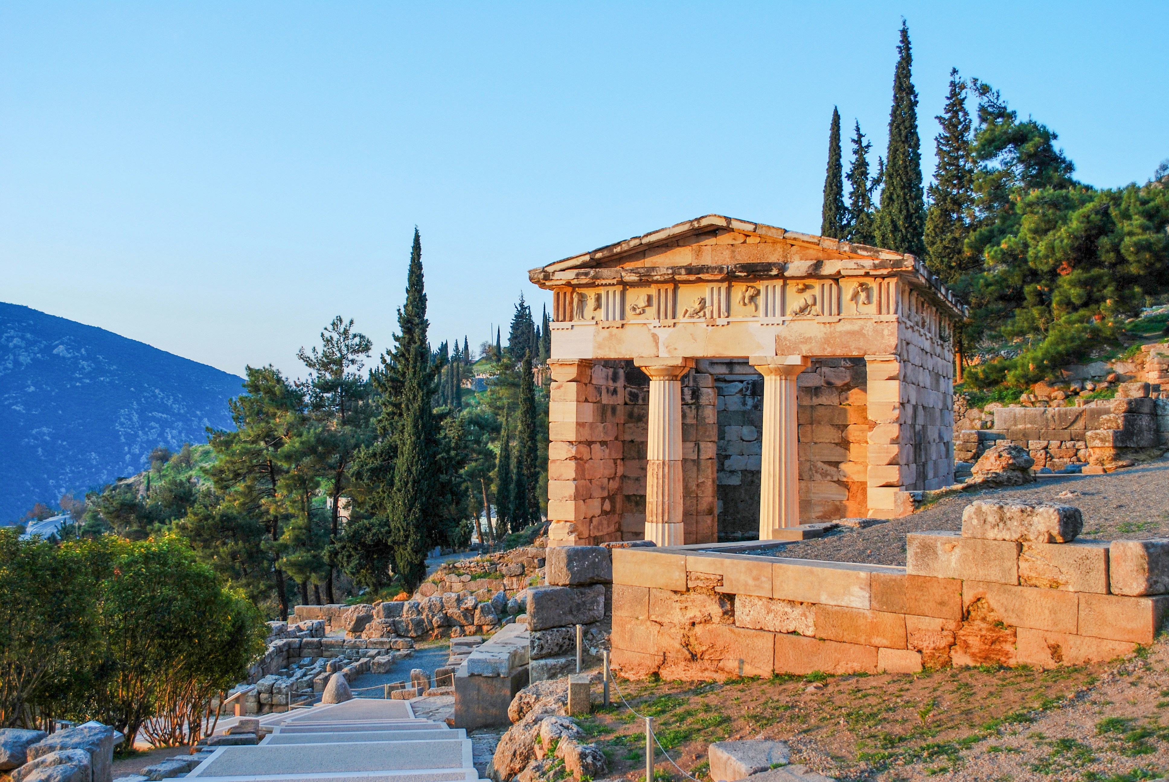 Athenian Treasury at Delphi with surrounding landscape and ancient ruins.