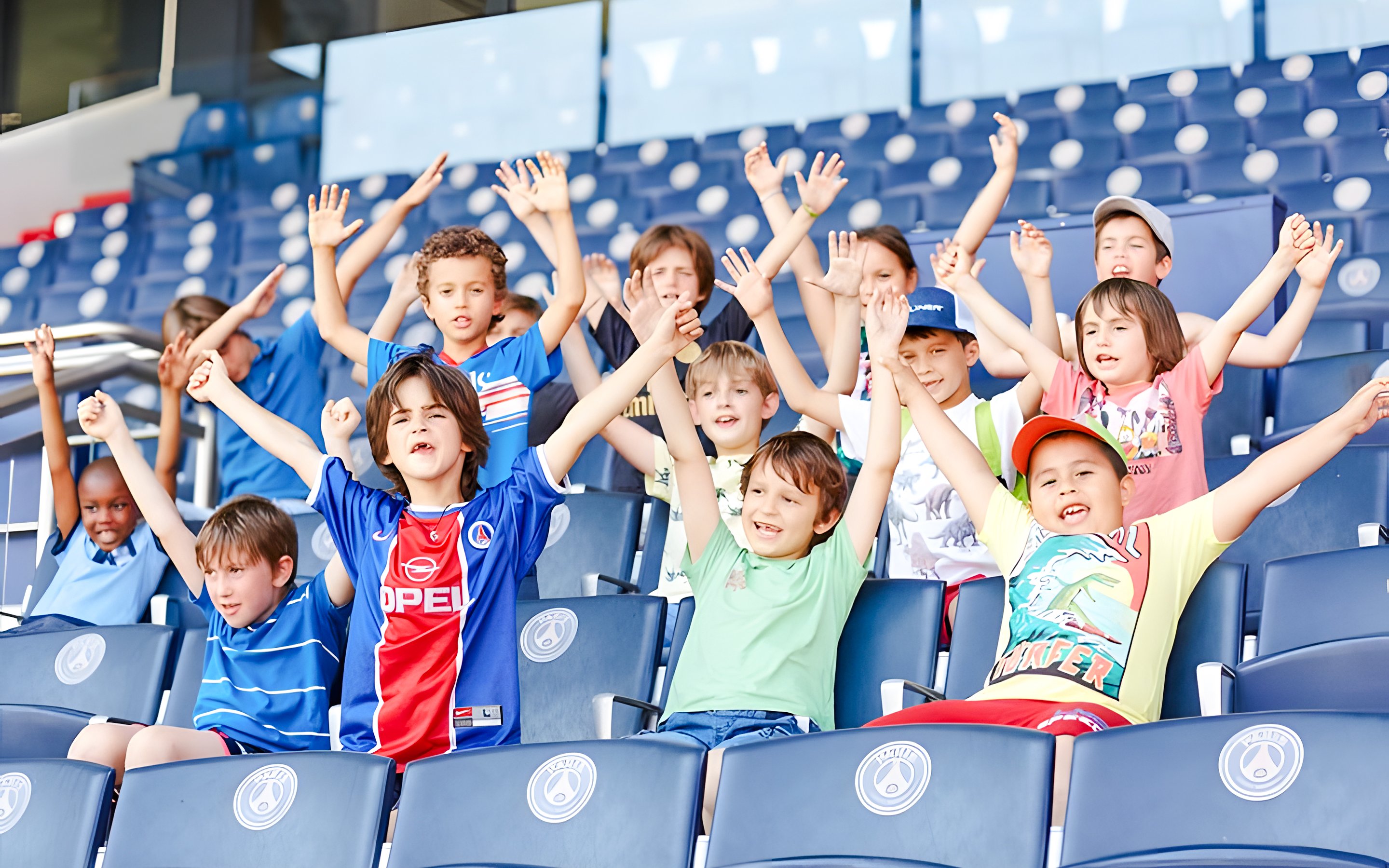 Children cheering in the stands at PSG Stadium, Paris, France.