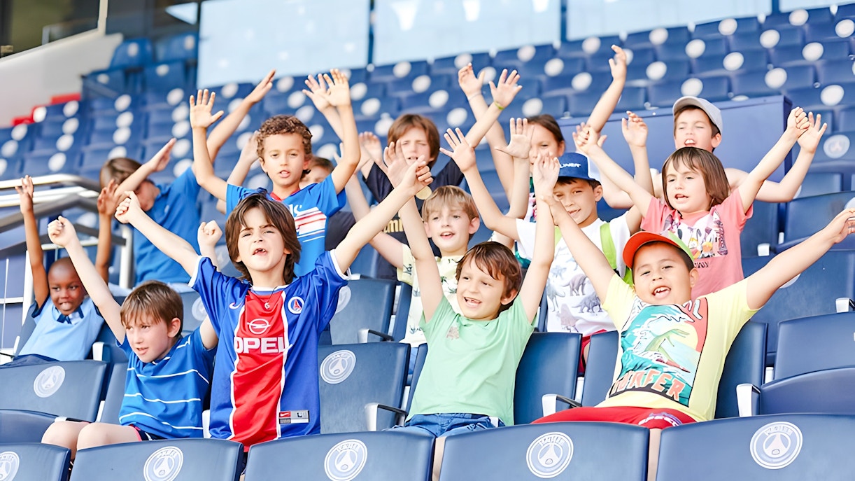 Children cheering in the stands at PSG Stadium, Paris, France.