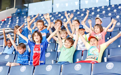Children cheering in the stands at PSG Stadium, Paris, France.