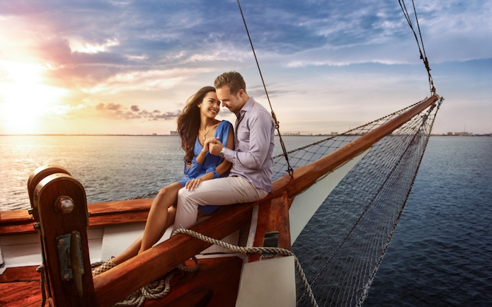 Couple enjoying a romantic sunset cruise on a boat in Cancun.