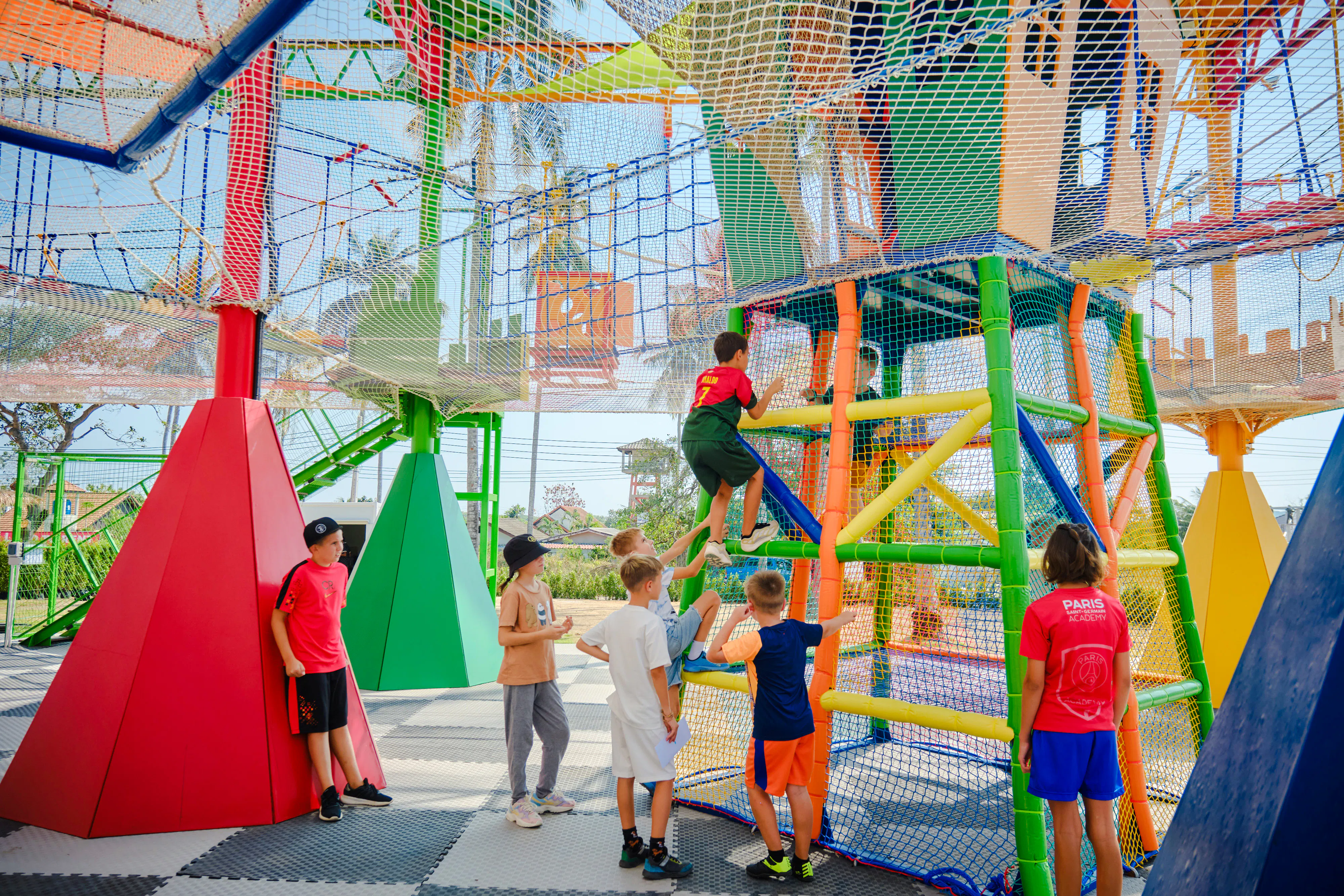 Children climbing colorful play structures at Ko Fun Kids Park, Phuket.