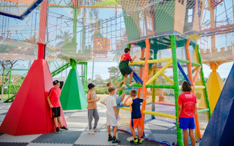 Children climbing colorful play structures at Ko Fun Kids Park, Phuket.