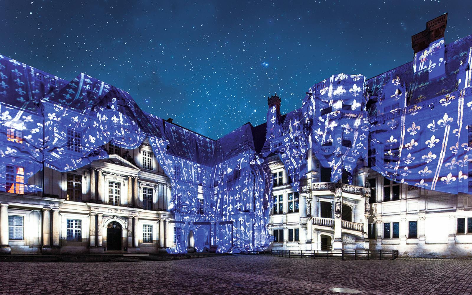 Sound and Light Show at Royal Château of Blois with illuminated facade and starry sky.