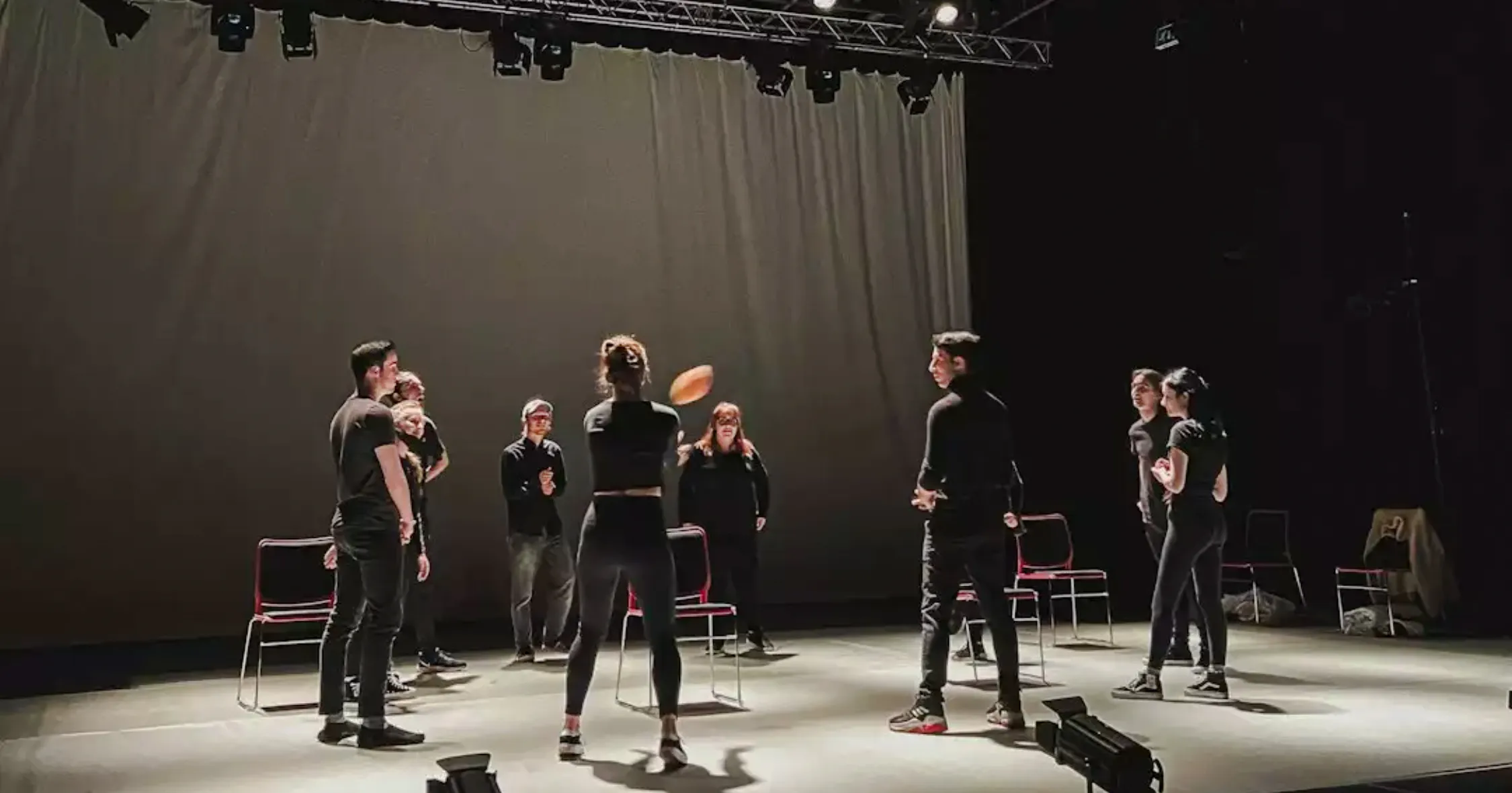 Theatre workshop participants in Essaouira practicing with professional actors on stage.