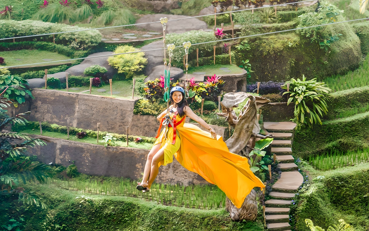 Lady ziplining at Alas Harum, Bali, surrounded by lush greenery.