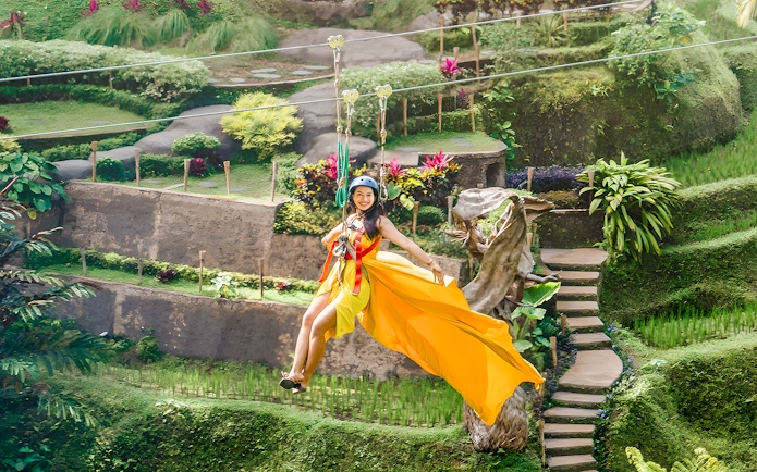 Lady ziplining at Alas Harum, Bali, surrounded by lush greenery.
