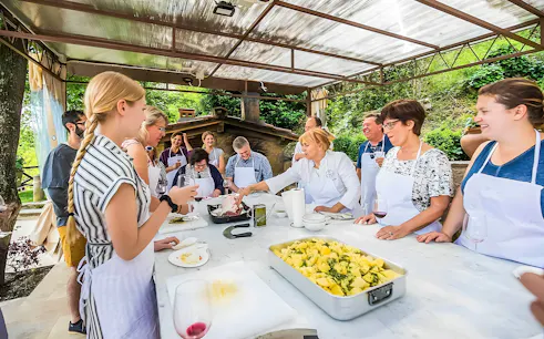 Cooking class participants preparing a dish in the Tuscan countryside.
