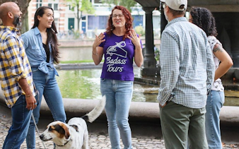 Tour guide leading a small group on a Jewish history tour by a canal.
