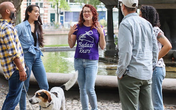 Tour guide leading a small group on a Jewish history tour by a canal.