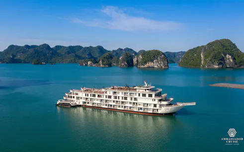 Luxury cruise ship in Ha Long Bay, Vietnam, surrounded by limestone islands.