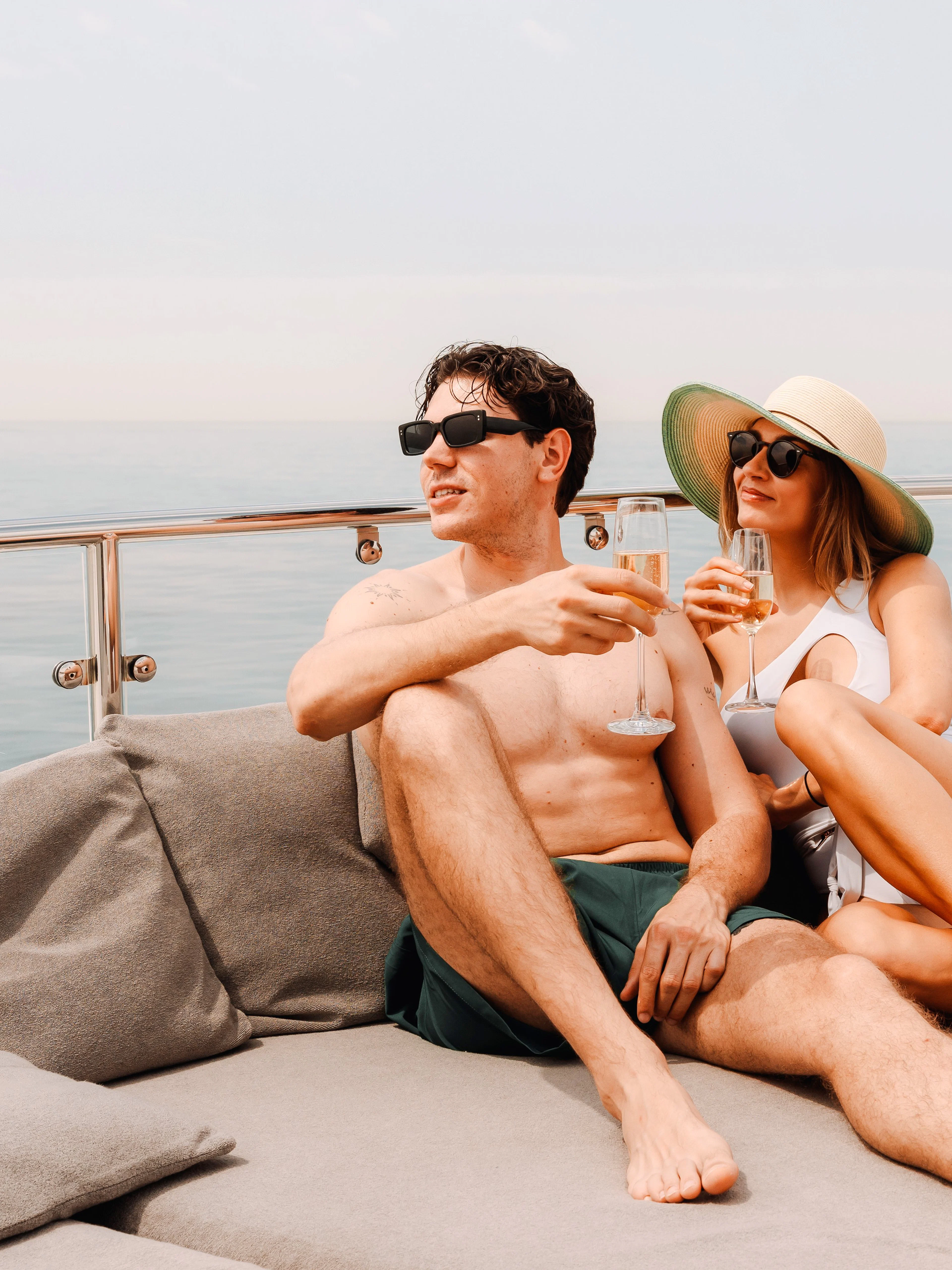 Couple relaxing on a luxury yacht cruise in Dubai, enjoying drinks on deck.