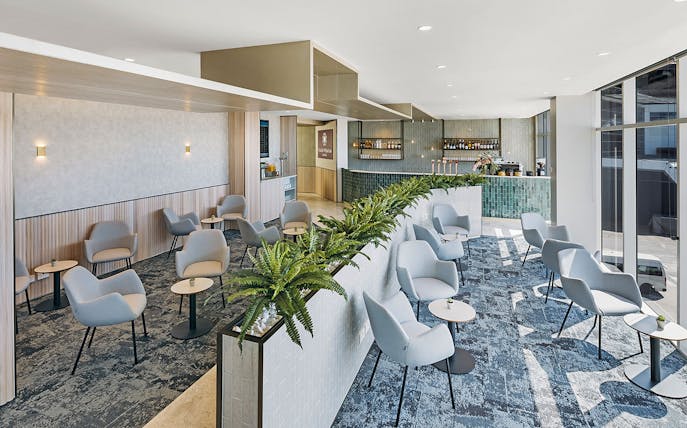 Plaza Premium Lounge seating area with modern chairs and tables near the bar, International Arrival.