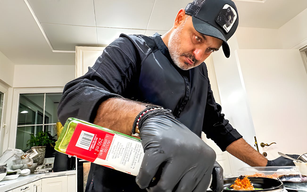 Private chef preparing a dish for a 10-course underground dining experience.