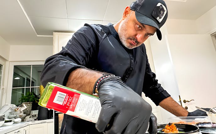 Private chef preparing a dish for a 10-course underground dining experience.