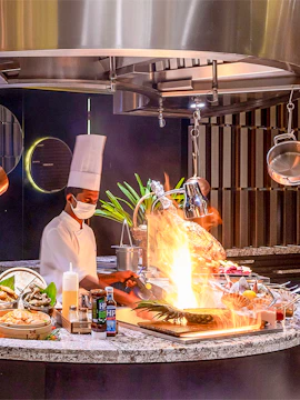 Chef cooking with flames at Mundo Jumeirah Emirates Towers, Dubai.