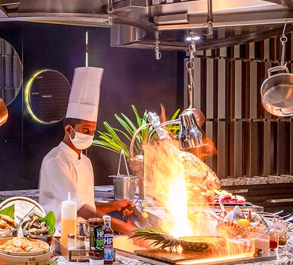 Chef cooking with flames at Mundo Jumeirah Emirates Towers, Dubai.