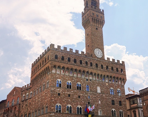Palazzo Vecchio in Florence with tourists in the square.