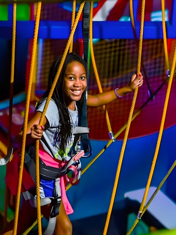 Child navigating ropes course at WonderWorks, Orlando theme park.
