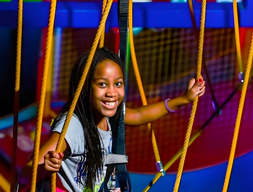 Child navigating ropes course at WonderWorks, Orlando theme park.