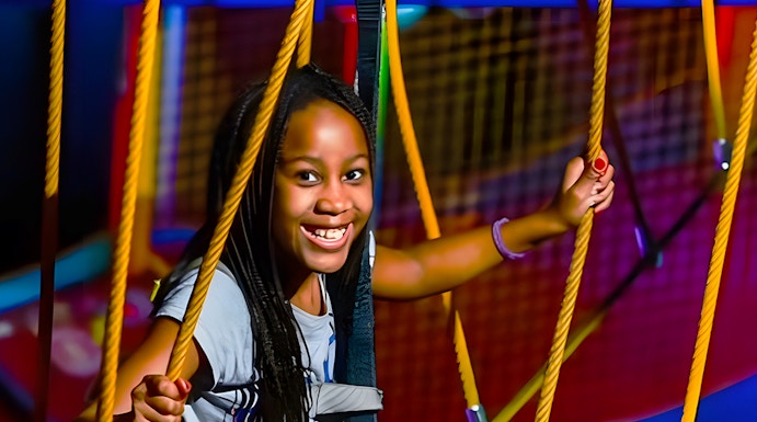 Child navigating ropes course at WonderWorks, Orlando theme park.