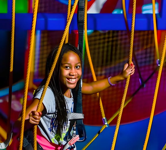 Child navigating ropes course at WonderWorks, Orlando theme park.