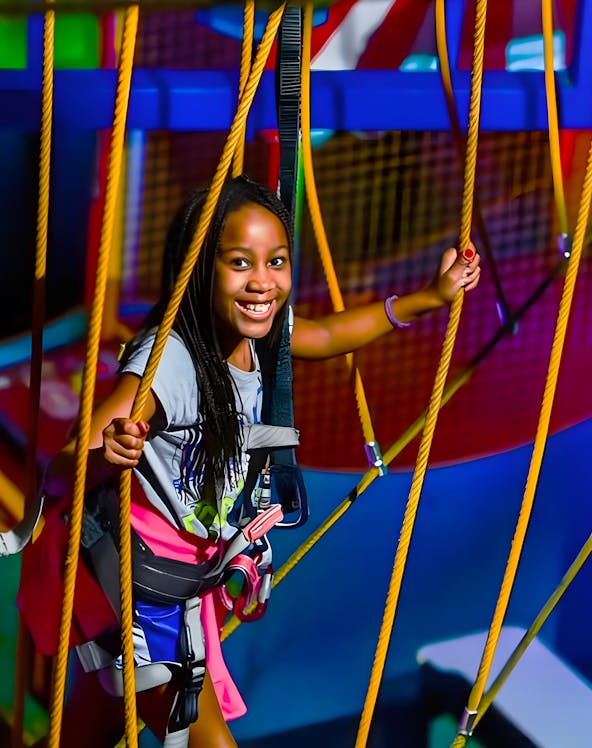 Child navigating ropes course at WonderWorks, Orlando theme park.