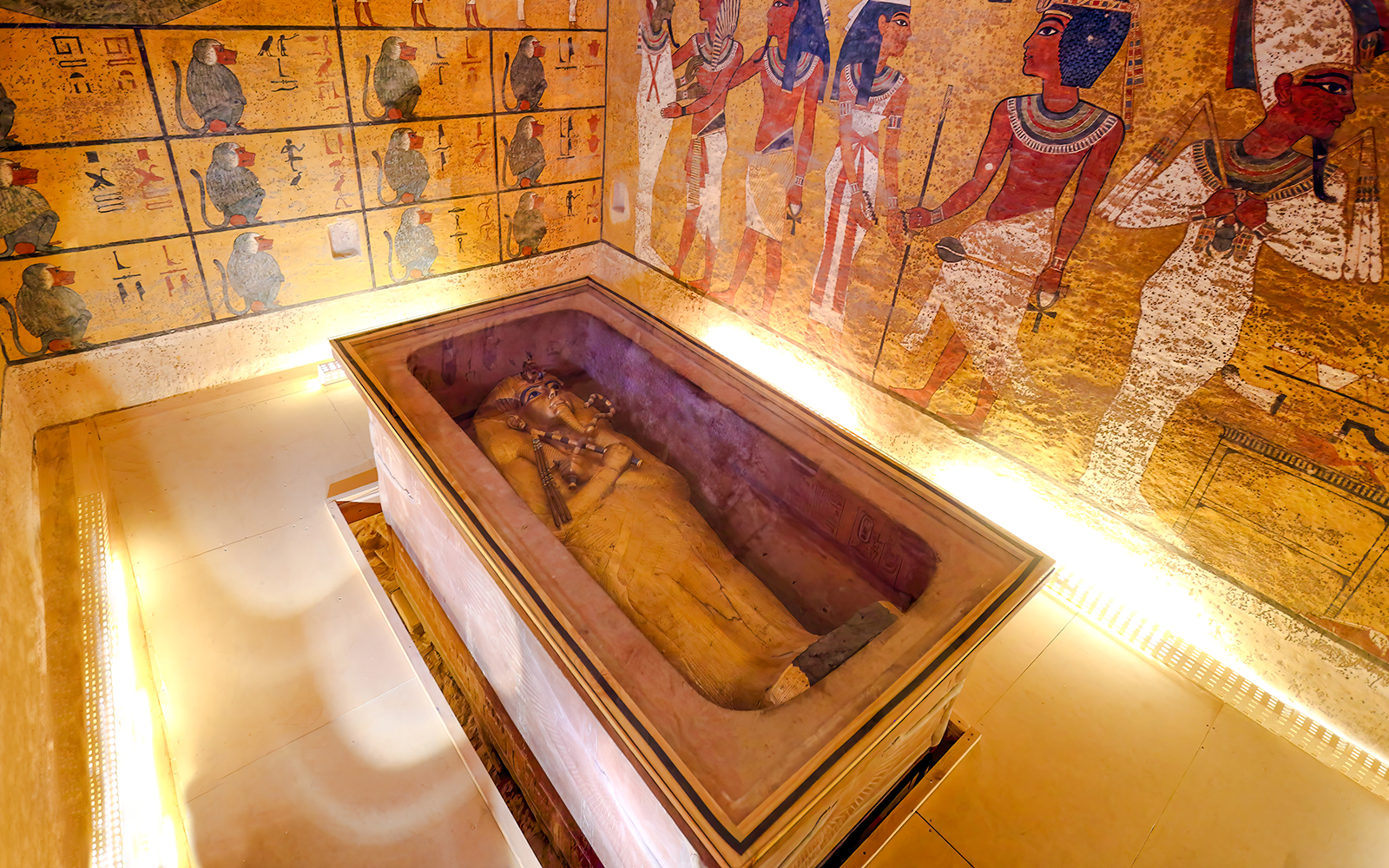 Sarcophagus in Luxor Temple's Valley of the Kings interior with ancient Egyptian wall art.
