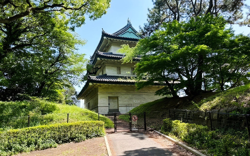 Imperial Palace building surrounded by lush greenery in Tokyo.