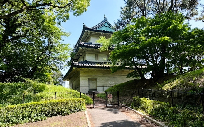 Imperial Palace building surrounded by lush greenery in Tokyo.