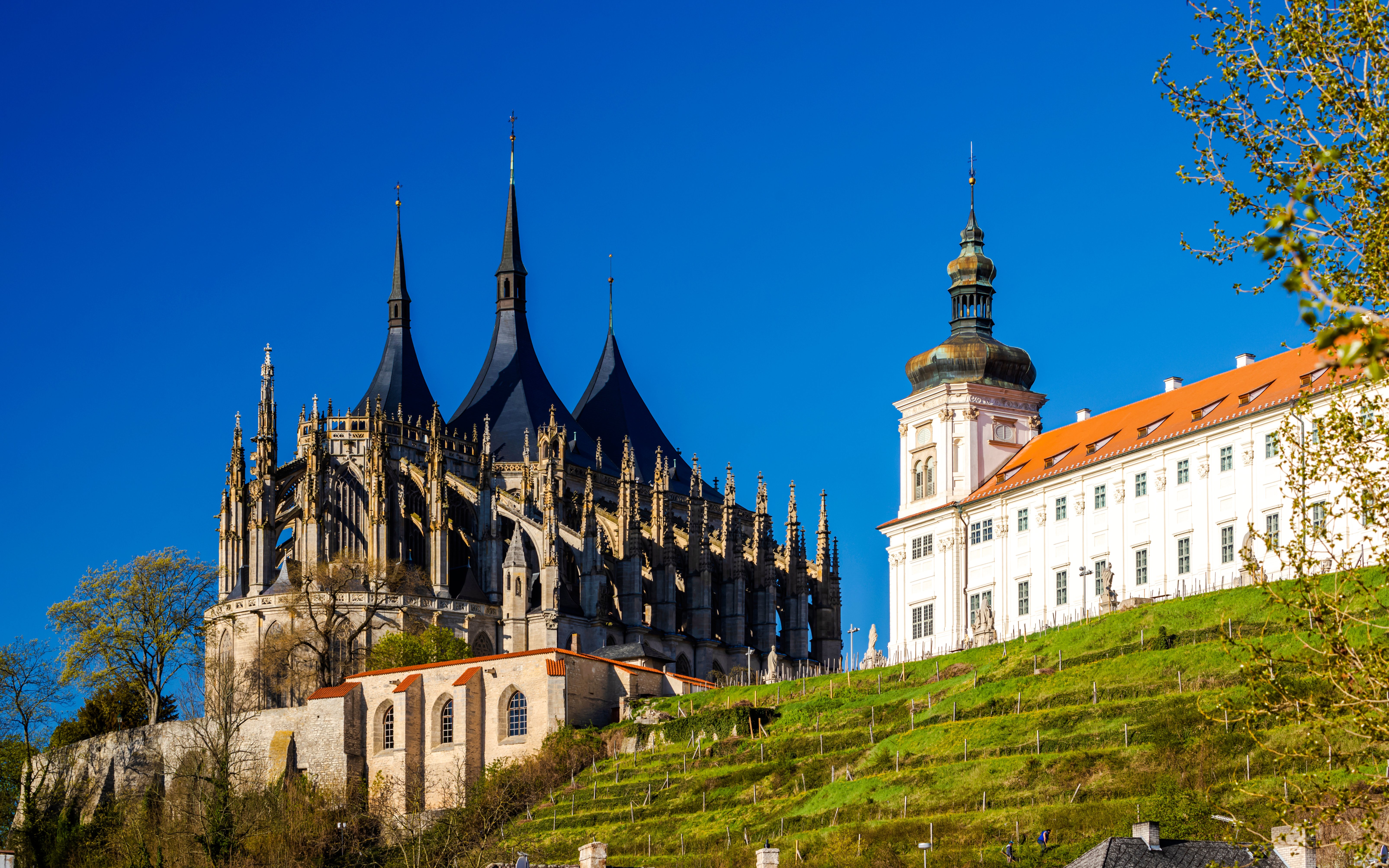 St. Barbara's Church with Gothic spires in Kutna Hora, Czech Republic, against a clear blue sky.