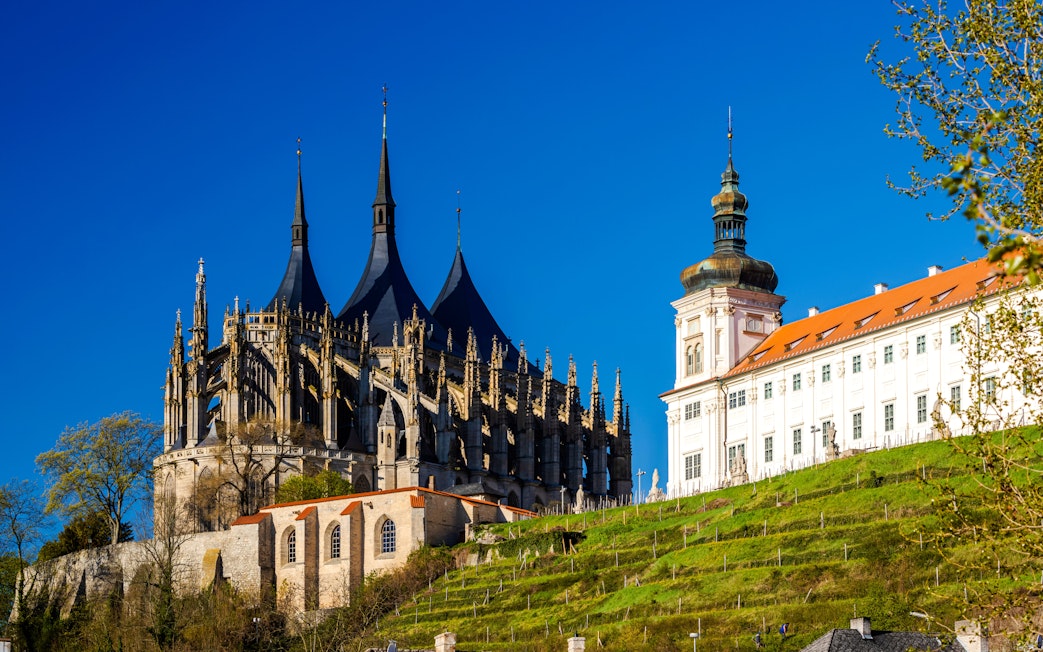 St. Barbara's Church with Gothic spires in Kutna Hora, Czech Republic, against a clear blue sky.