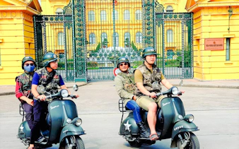 Tourists on Vespas in front of Presidential Palace gates, Hanoi.