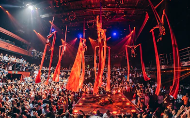 Aerial performers on red silks at Coco Bongo Club, Punta Cana with a lively crowd.