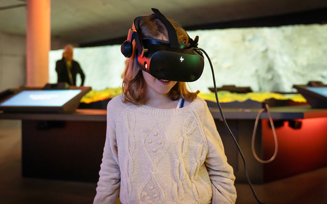 Child experiencing virtual reality at Espai Crater exhibit.