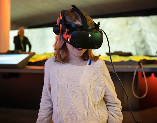 Child experiencing virtual reality at Espai Crater exhibit.